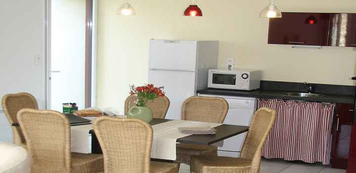 Vue de la cuisine, la table et la porte d'entrée de la location maison de vacances avec piscine en vendée